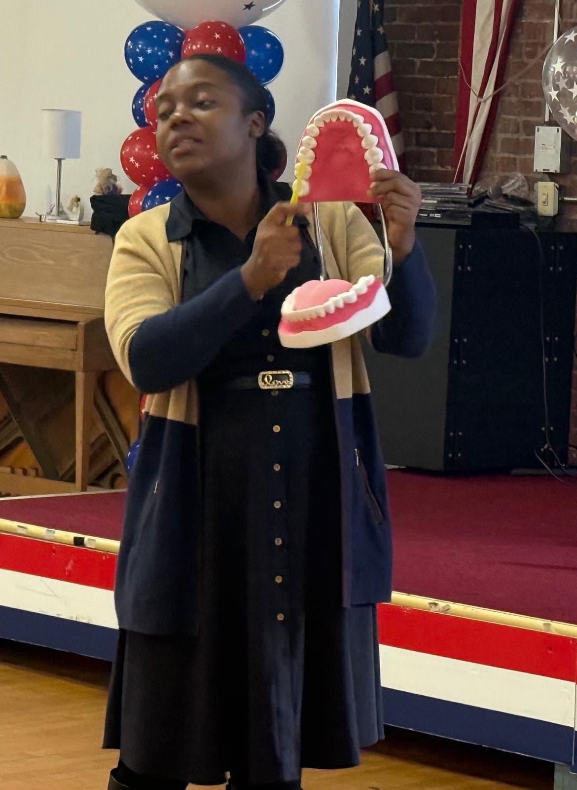 Dr. Esther Chrysostome demonstrating proper brushing technique with a dental model