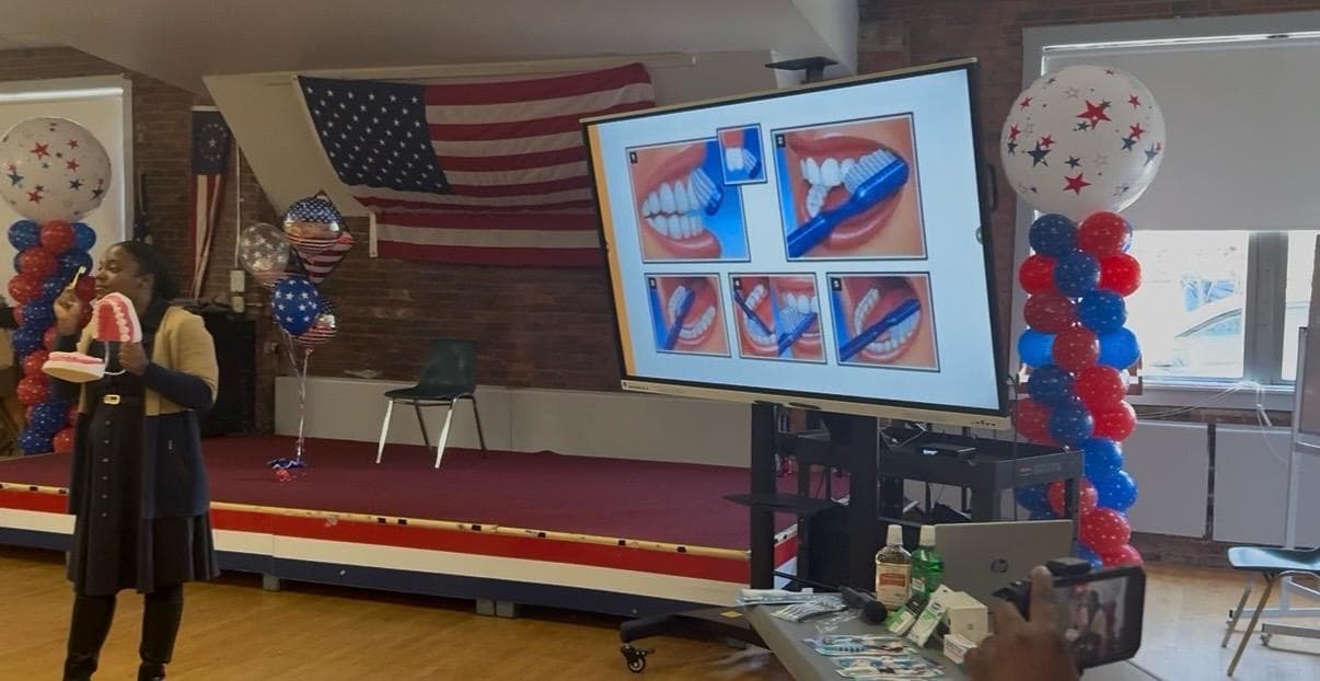 Brushing technique diagram displayed on screen during the AWMI oral health workshop