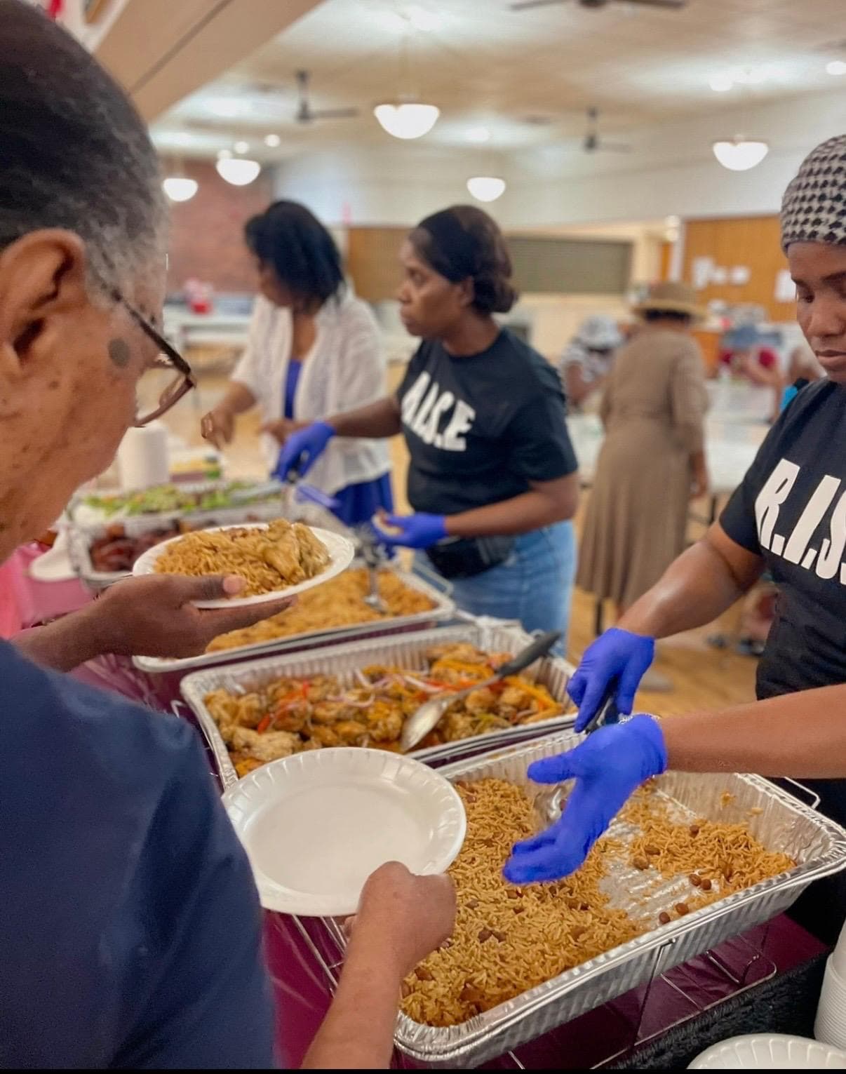 R.I.S.E. volunteers serving a community meal to participants